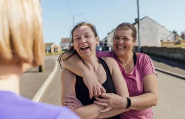 Two women embracing and smiling together.